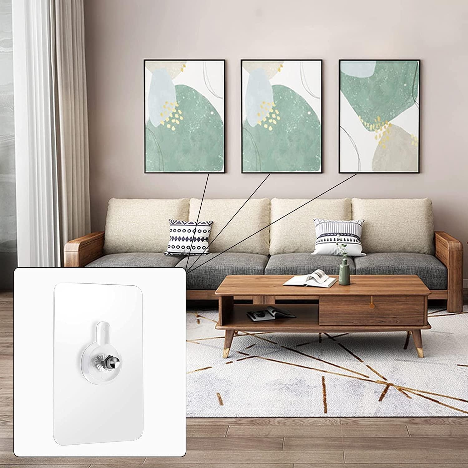 A modern living room with a wooden sofa, beige cushions, a wooden coffee table, and three abstract green and white paintings. An inset shows close-up Wall Mount Screw Hooks for Kitchen Bathroom Bedroom Living Room (10 Pcs) on the wall.